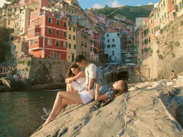 Three people relaxing by the sea in Riomaggiore, Cinque Terre - Contiki Tuscany, Milan & Venice Tour