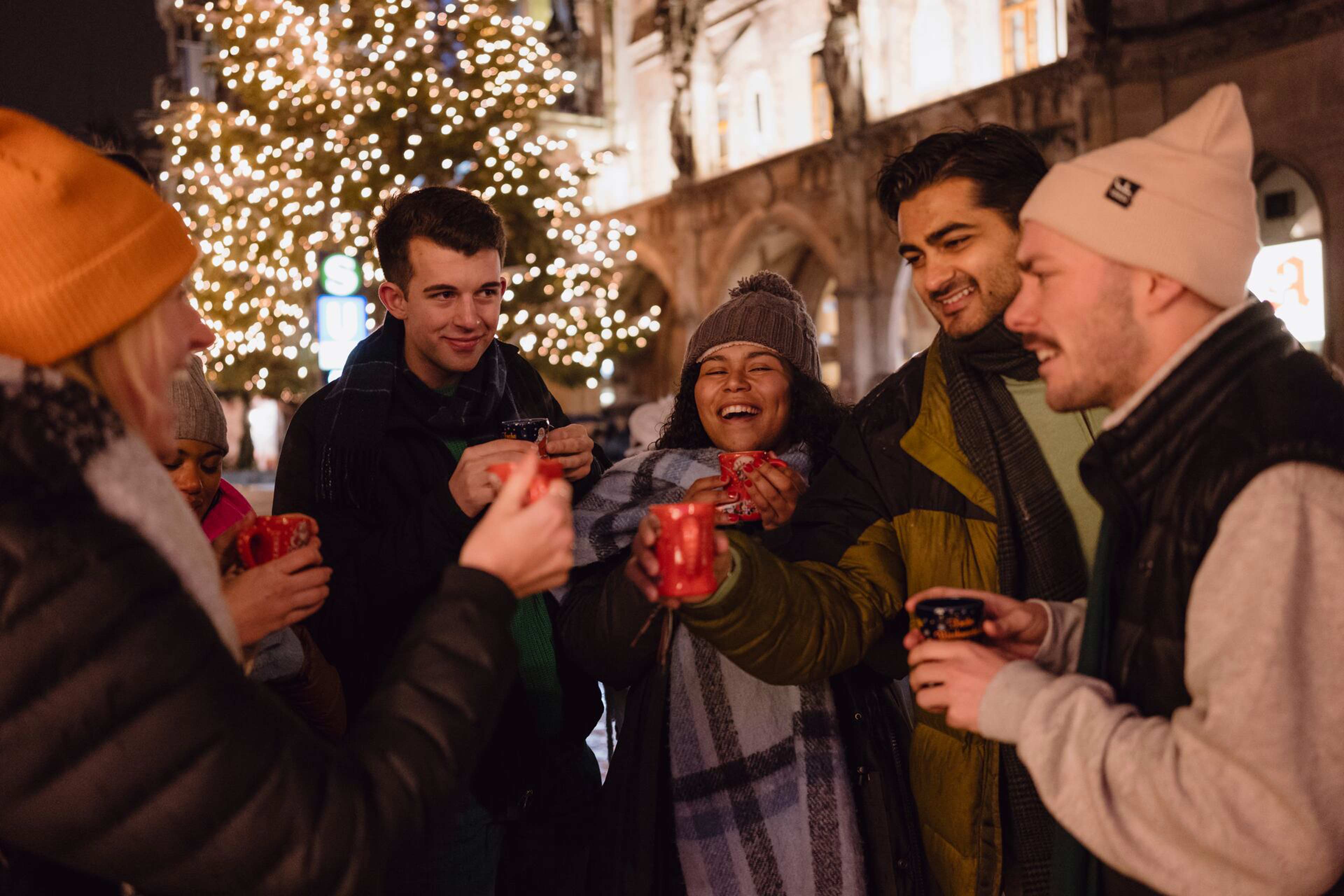 Group of friends enjoying mulled wine at Christmas market
