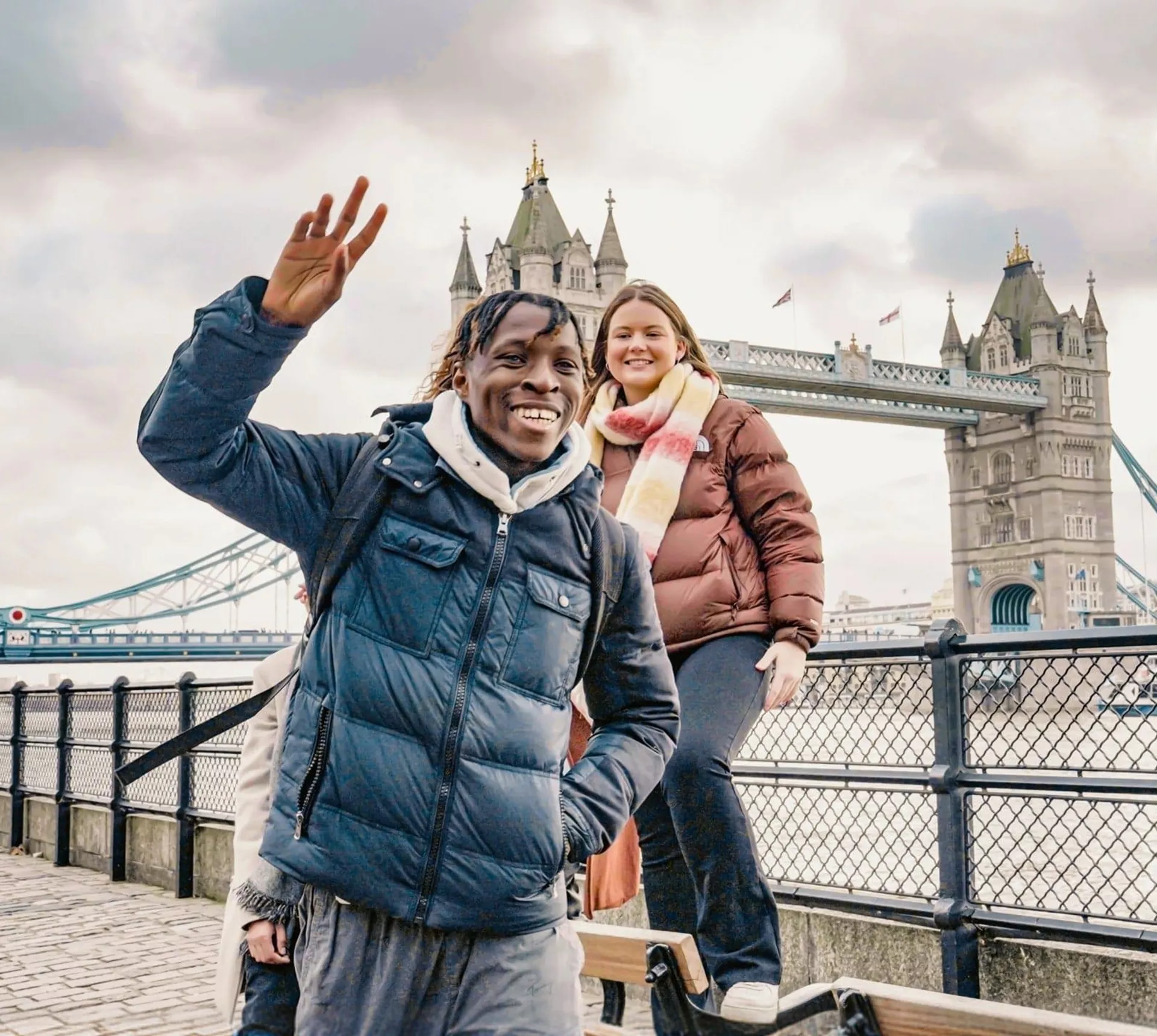 Contiki ravellers posing in front of Tower Bridge in London on Contiki's England in a Week Tour, exploring one of England's most iconic landmarks