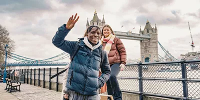 Contiki ravellers posing in front of Tower Bridge in London on Contiki's England in a Week Tour, exploring one of England's most iconic landmarks