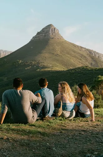 Travellers enjoy panoramic views of Table Mountain and Lion's Head overlooking Cape Town on the Contiki Cape Town, Safari & Falls Tour