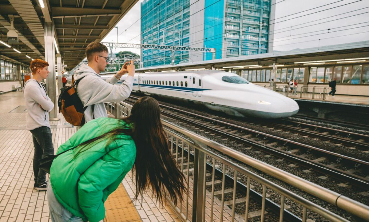 Group Taking Photo Of Bullet Train