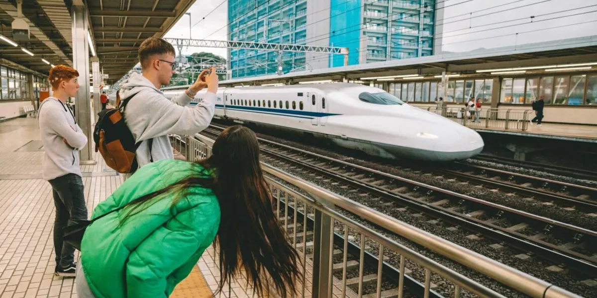 Group Taking Photo Of Bullet Train