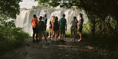 Contiki travellers viewing Victoria Falls from a rainforest lookout on the Victoria Falls Mini Break Tour