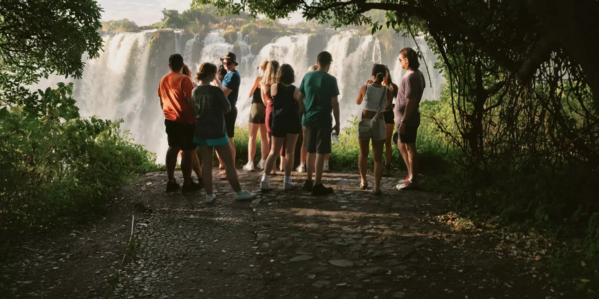 Contiki travellers viewing Victoria Falls from a rainforest lookout on the Victoria Falls Mini Break Tour