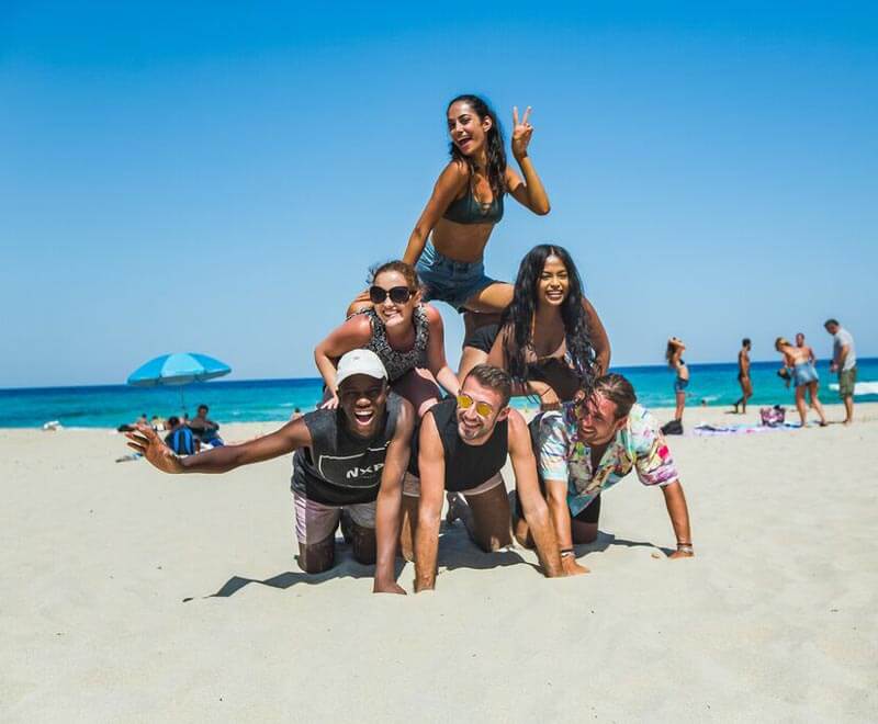 People forming pyramid on a beach
