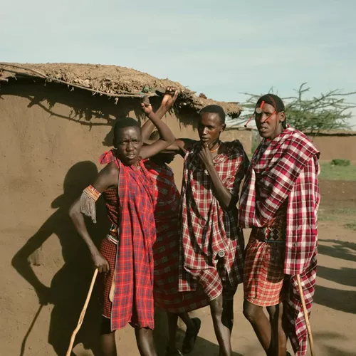 Group meet Maasai community members in a traditional village during Contiki's Kenya: Maasai Mara & Safari Tour