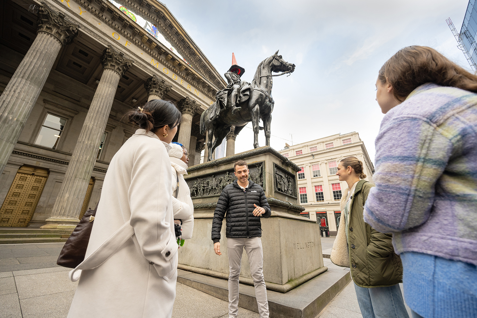 Travellers listening to the trip manager whilst in Glasgow, Scotland