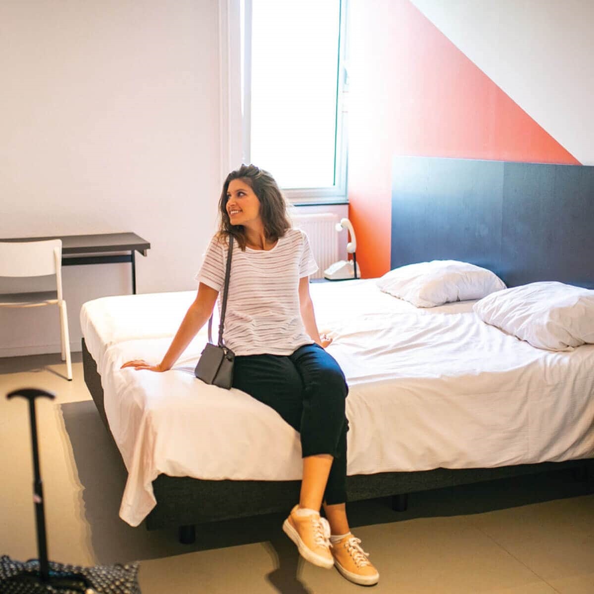 Smiling girl sitting on hotel bed