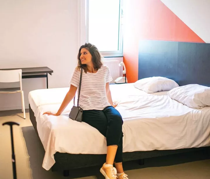 Smiling girl sitting on hotel bed