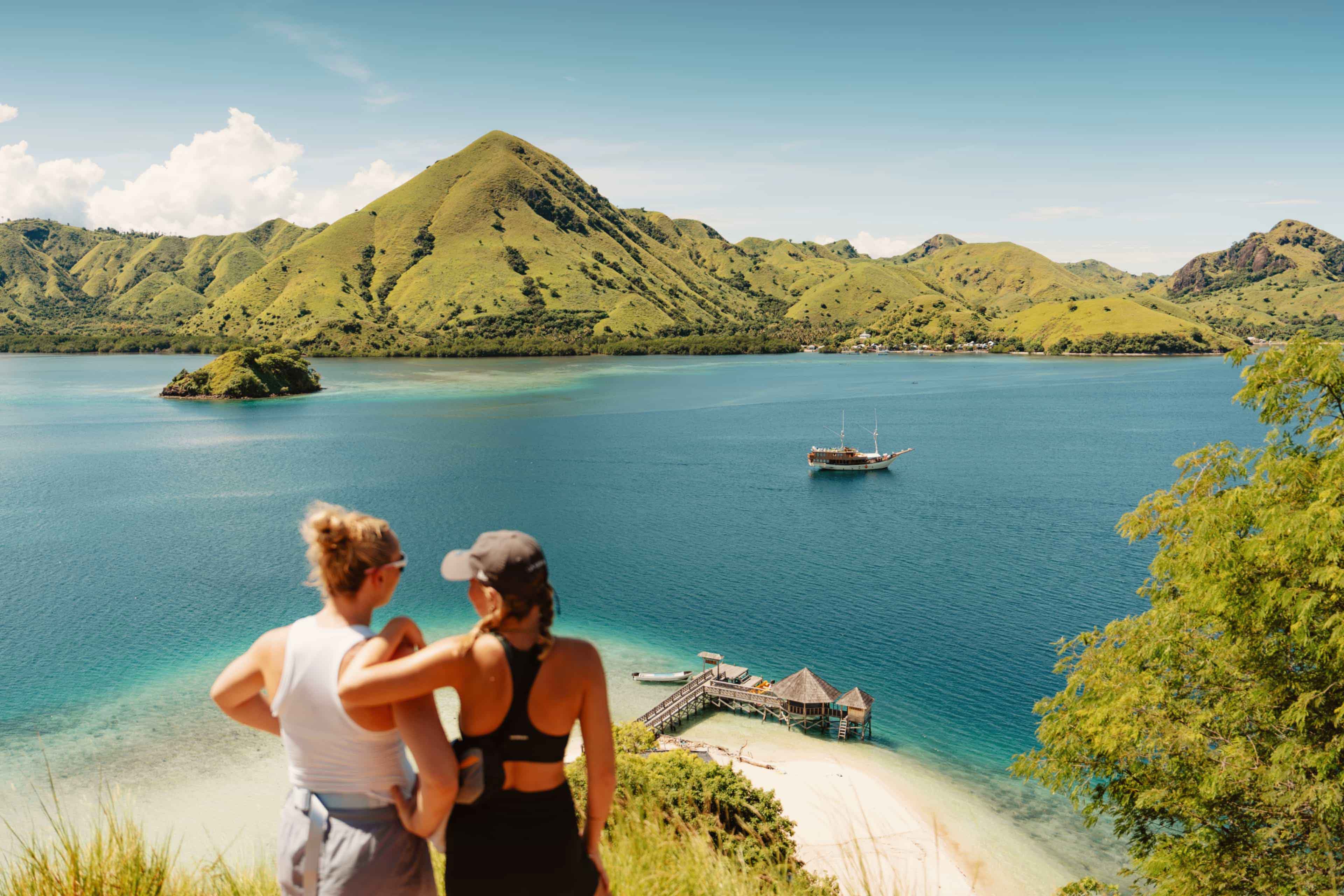 Two friends enjoying the scenic view of Kelor Island, Komodo National Park, Indonesia