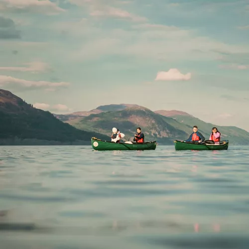 Contiki travellers canoeing across Loch Ness, surrounded by the Scottish Highlands, enjoying an unforgettable outdoor adventure on the Scotland in a Week 35 to 45 Tour