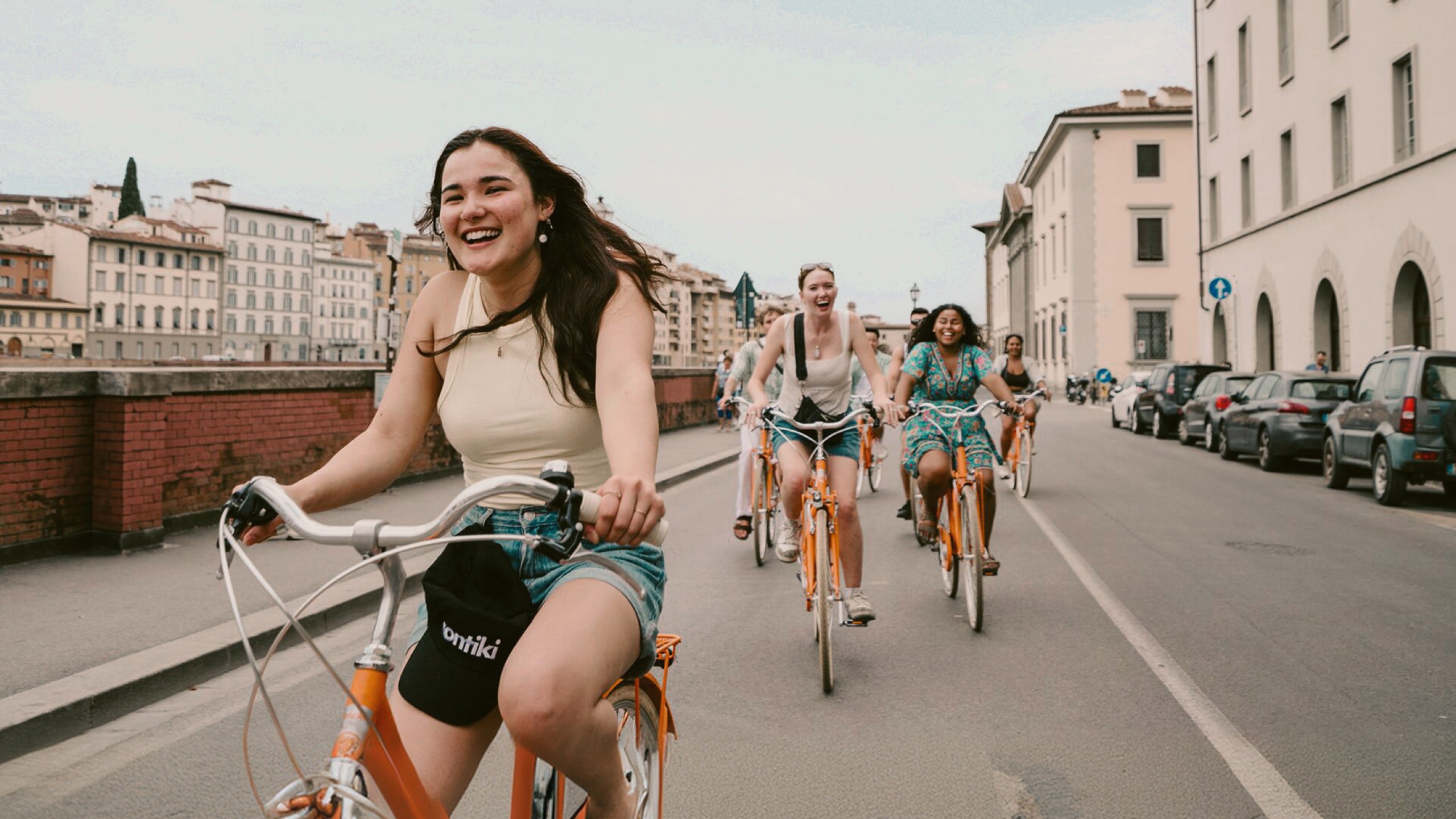 Contiki travellers cycling through the historic streets of Florence, Italy, on the Vienna to London Trail Tour