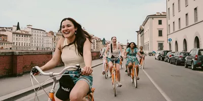 Contiki travellers cycling through the historic streets of Florence, Italy, on the Vienna to London Trail Tour