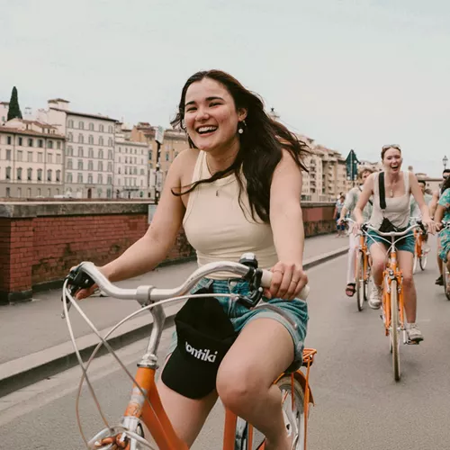 Contiki travellers cycling through the historic streets of Florence, Italy, on the Vienna to London Trail Tour