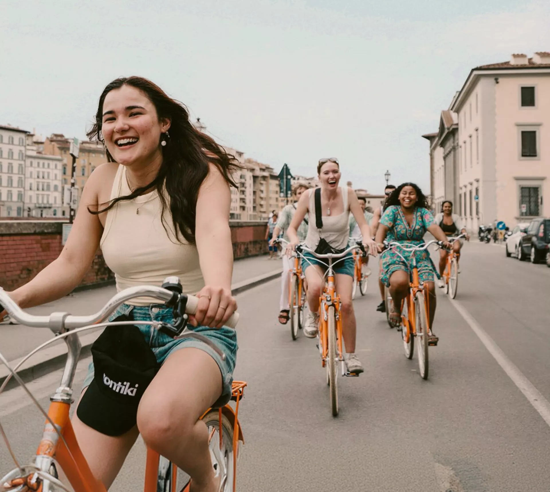 Contiki travellers cycling through the historic streets of Florence, Italy, on the Vienna to London Trail Tour