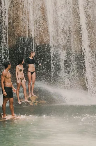 Travellers swimming beneath a tropical waterfall in Northern Thailand - Contiki Chiang Mai & Pai Tour