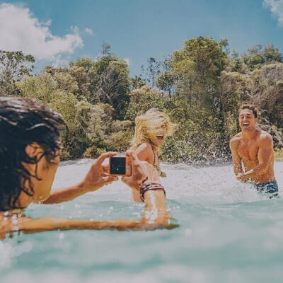 Travellers taking photo in water, Australia