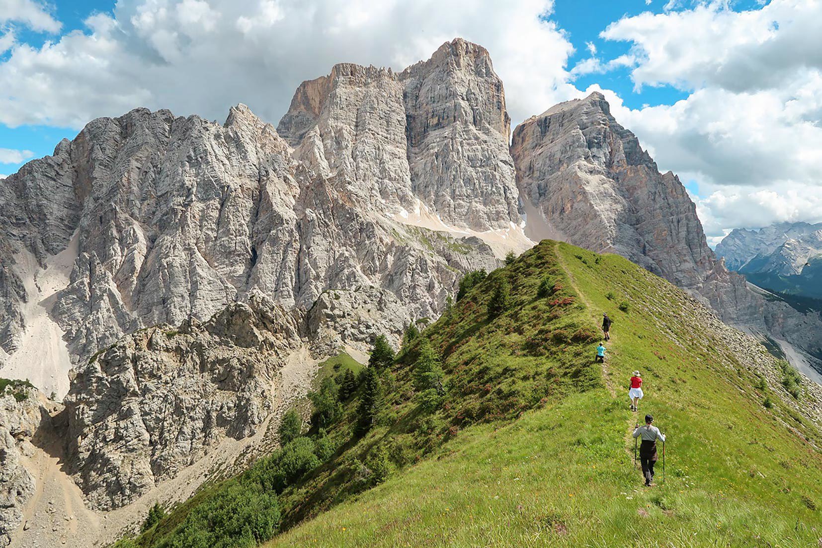 Travellers walking on a verge looking at a mountain range in Dolomites, Italy