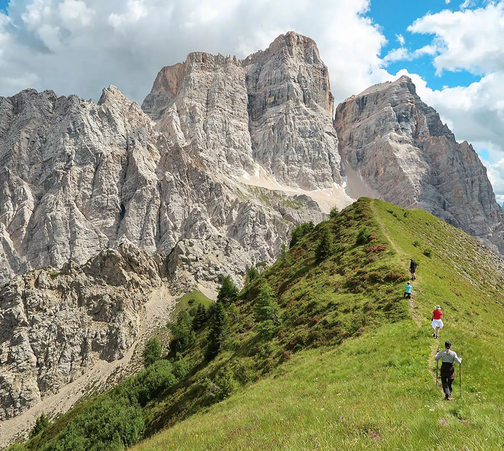 Travellers walking on a verge looking at a mountain range in Dolomites, Italy