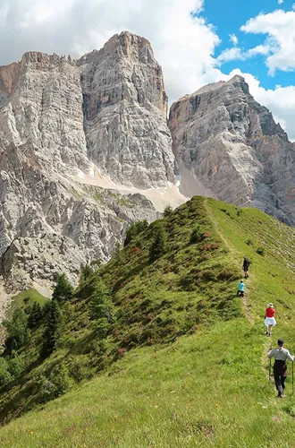 Travellers walking on a verge looking at a mountain range in Dolomites, Italy