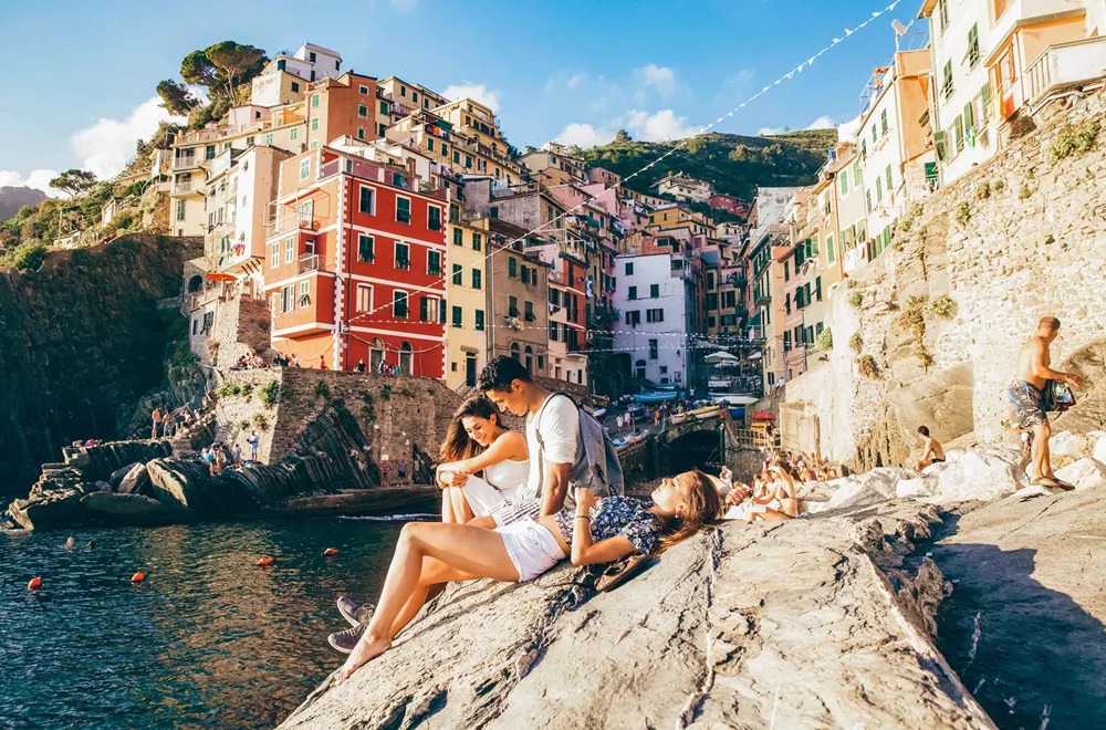 People Sat On Rocks In Italy