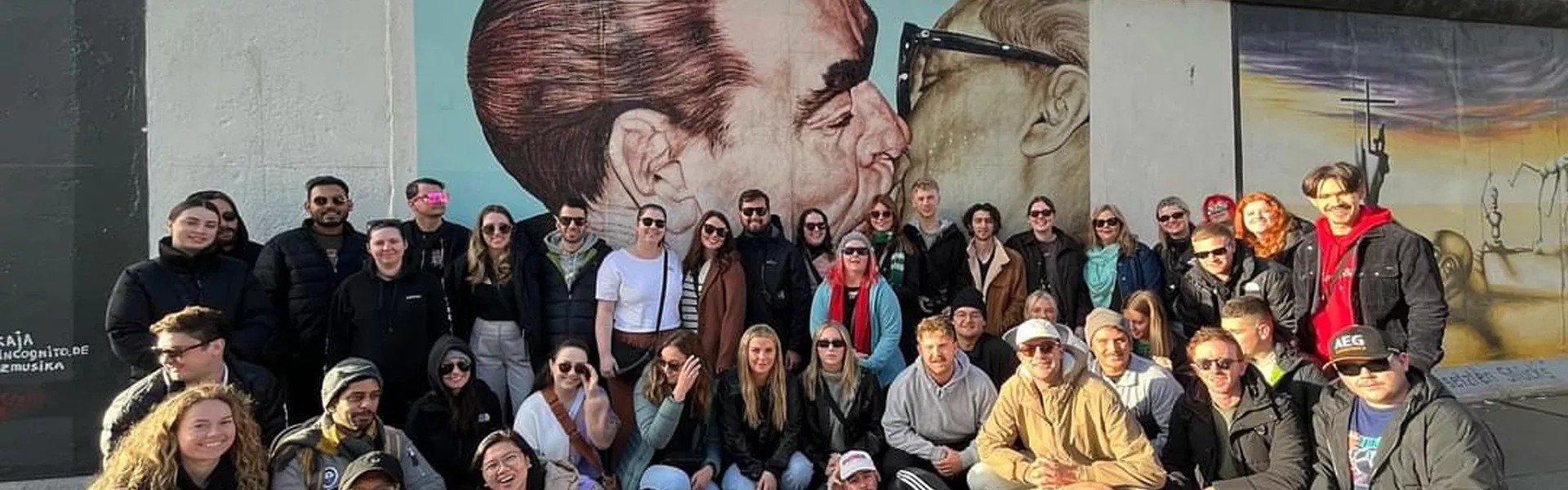 A group of people standing close to graffiti in Germany.