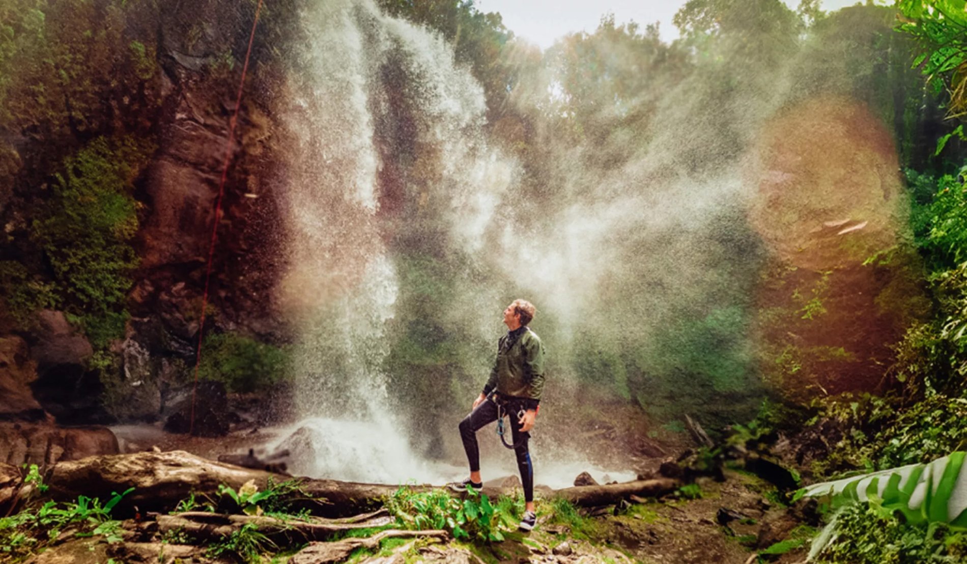 Man looking at waterfall in Ecuador. 