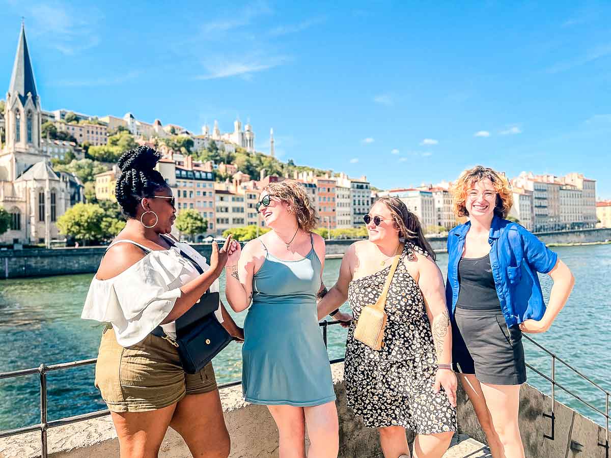 Four Young Female Travelers Laughing In The Sun