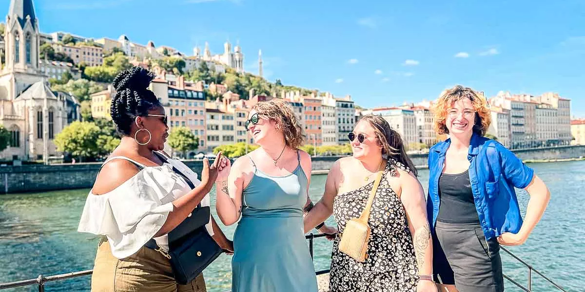 Four Young Female Travelers Laughing In The Sun