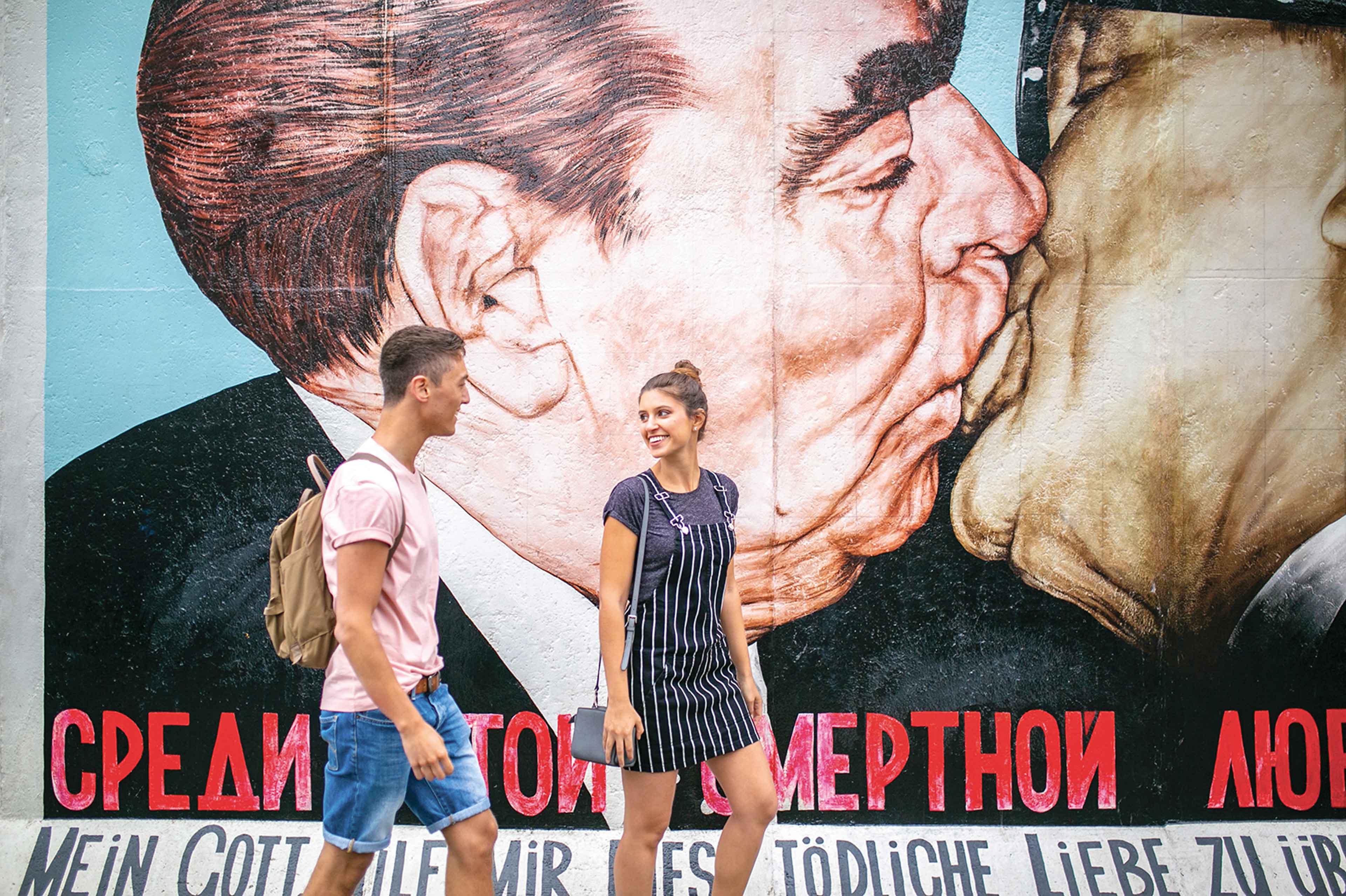 Tourists In Berlin Germany on the background of mural