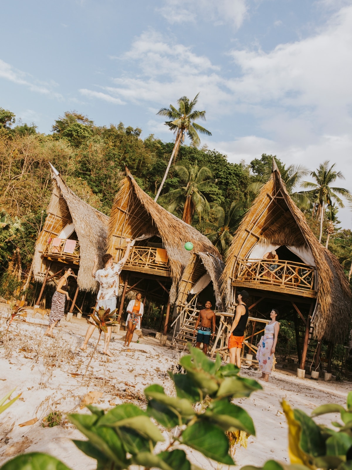 Travellers outside traditional beachfront accommodation on a tropical island in the Philippines.