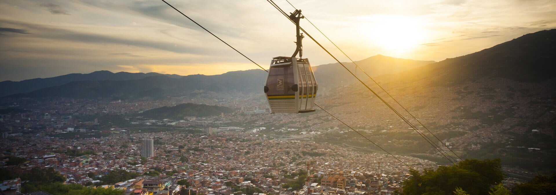 Metrocable over Medellin panorama with mountains at dusk, Colombia