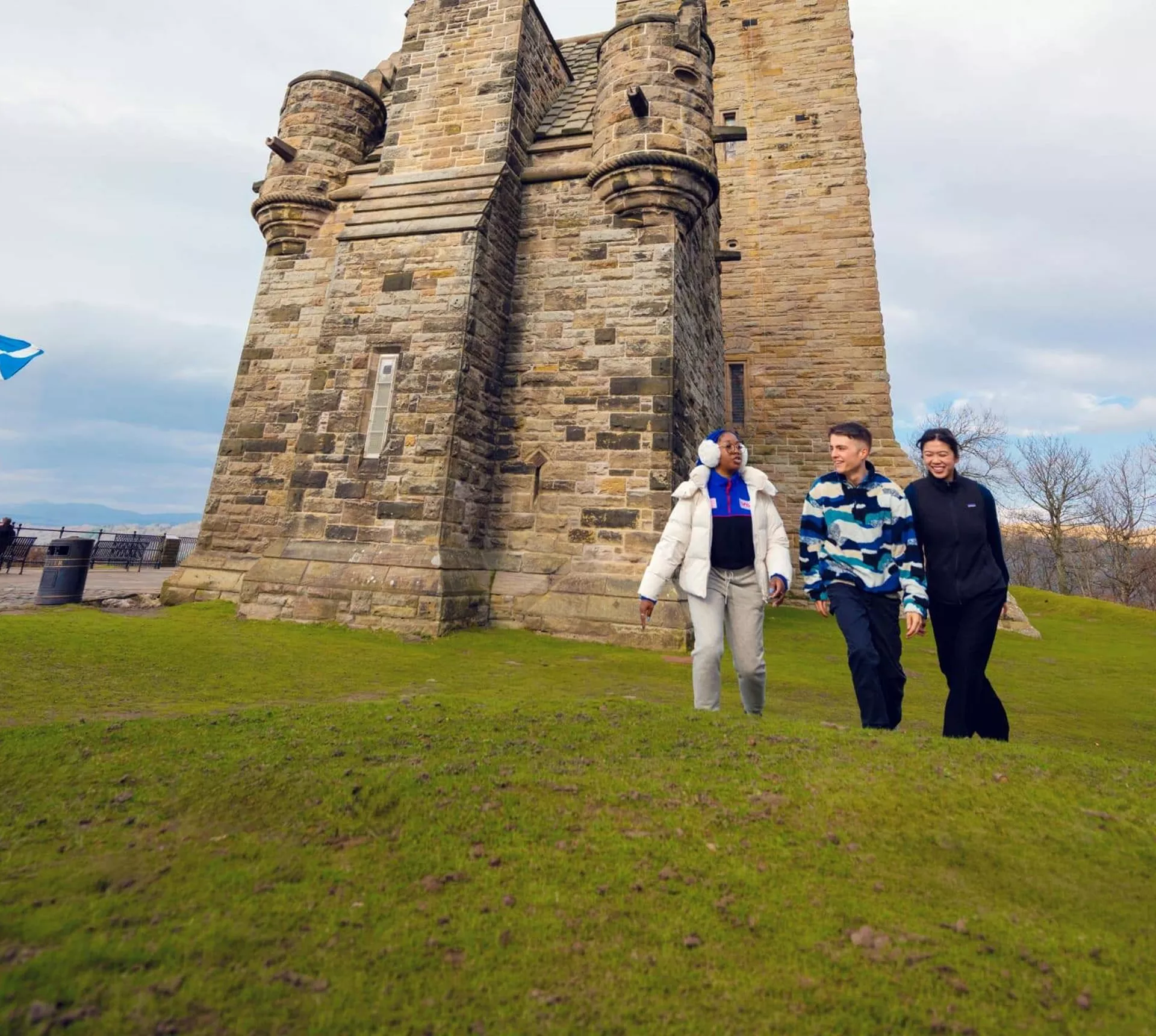 Travellers walk beside the National Wallace Monument in Stirling, Scotland, on the Contiki Best of Scotland & Ireland Tour
