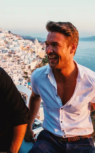 Friends enjoying sunset views over Santorini's whitewashed villages on Contiki's Athens to Santorini 35 to 45 Tour