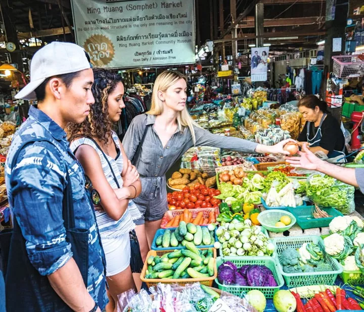 Travellers buying fruits and vegetables in Market in Chiang Mai, Thailand