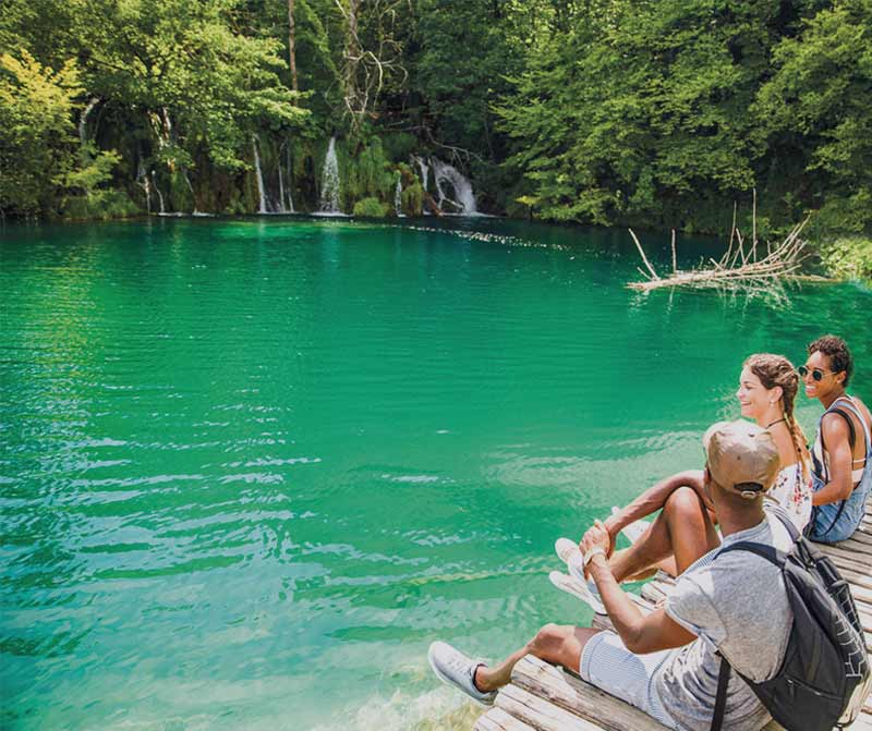 Friends sitting by the lake
