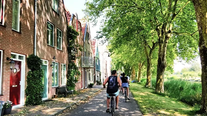 Travellers riding bikes in Edam, Netherlands