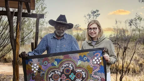 Man and woman holding a large decorated cloth