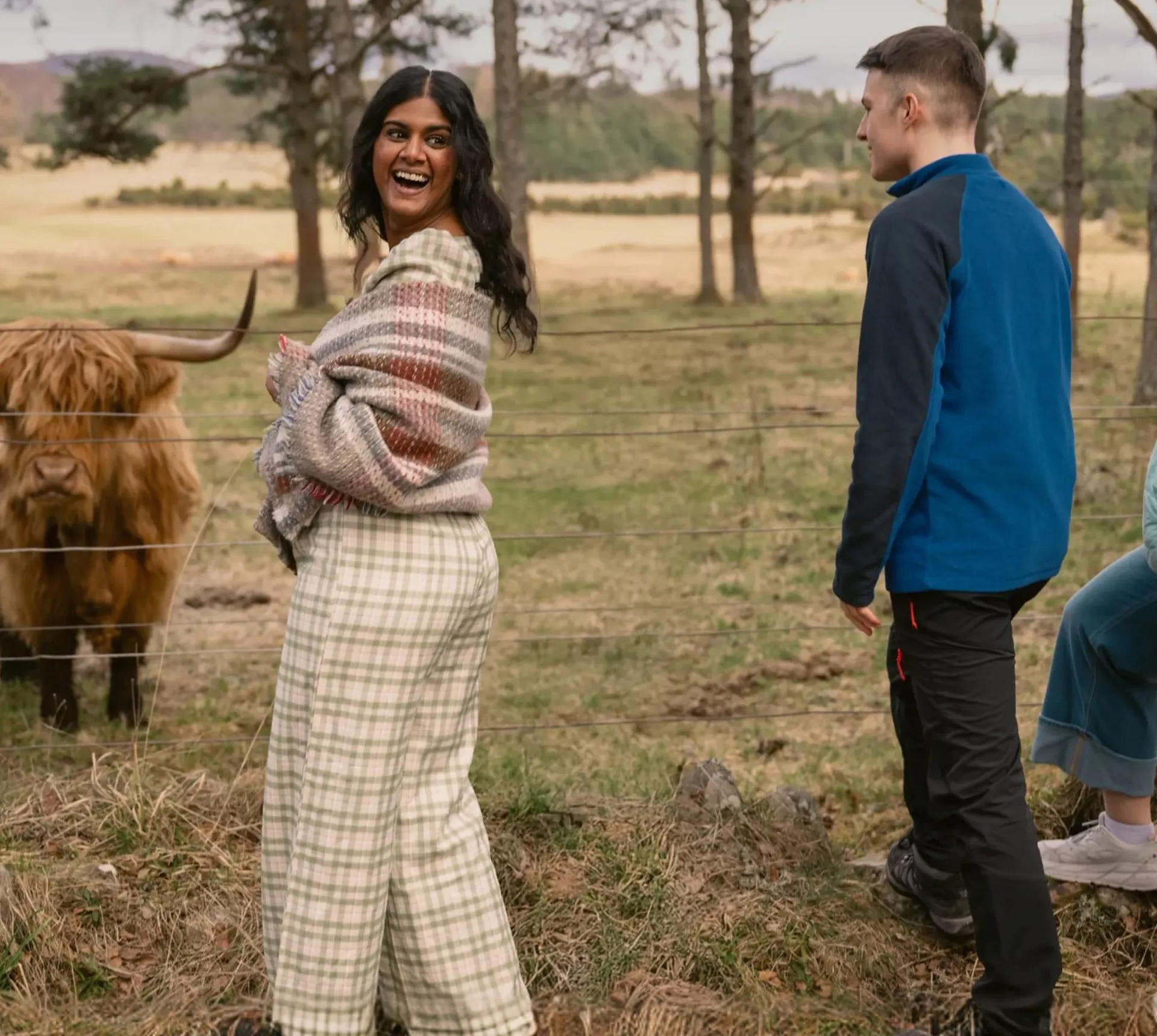 A group meeting a Highland cow in the Scottish Highlands - Contiki Scotland in a Week tour