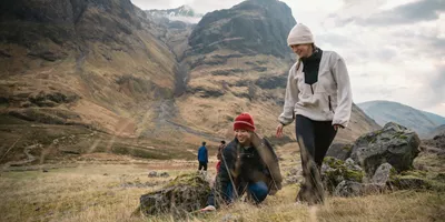 Two people walking through Glencoe in the Scottish Highlands - Contiki Best of Scotland & Ireland Tour