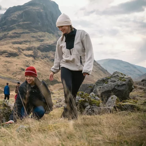 Two people walking through Glencoe in the Scottish Highlands - Contiki Best of Scotland & Ireland Tour