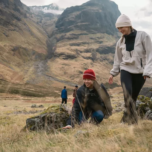 Two people walking through Glencoe in the Scottish Highlands - Contiki Best of Scotland & Ireland Tour