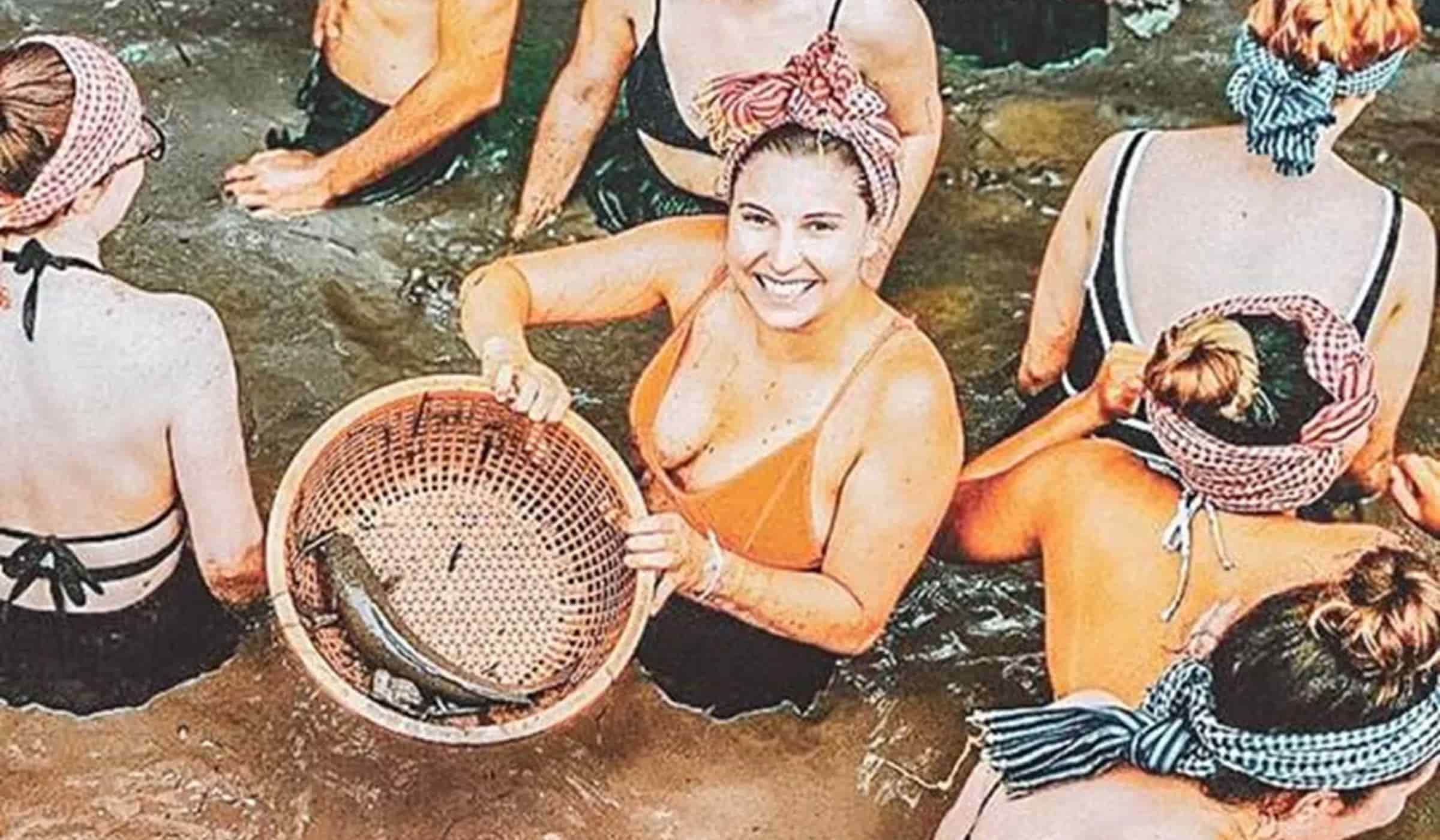 Traveller smiling while holding a bamboo fish basket during a traditional catch experience in a river of the Mekong Delta, Vietnam.