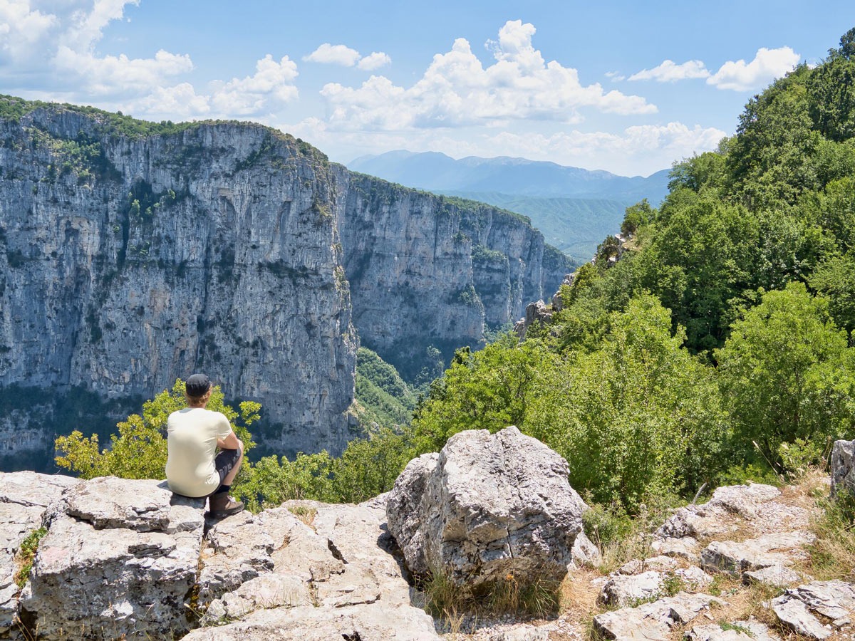 A young man enjoys the beautiful view over the mountains in Greece.