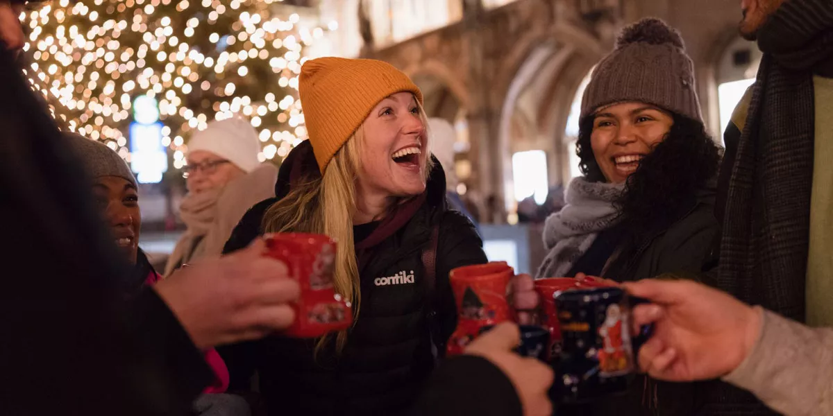 Friends0enjoying A Hot Drink In A Christmas Market