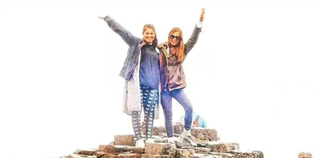 Travelers standing on the top of Giants Causeway. Northern Ireland