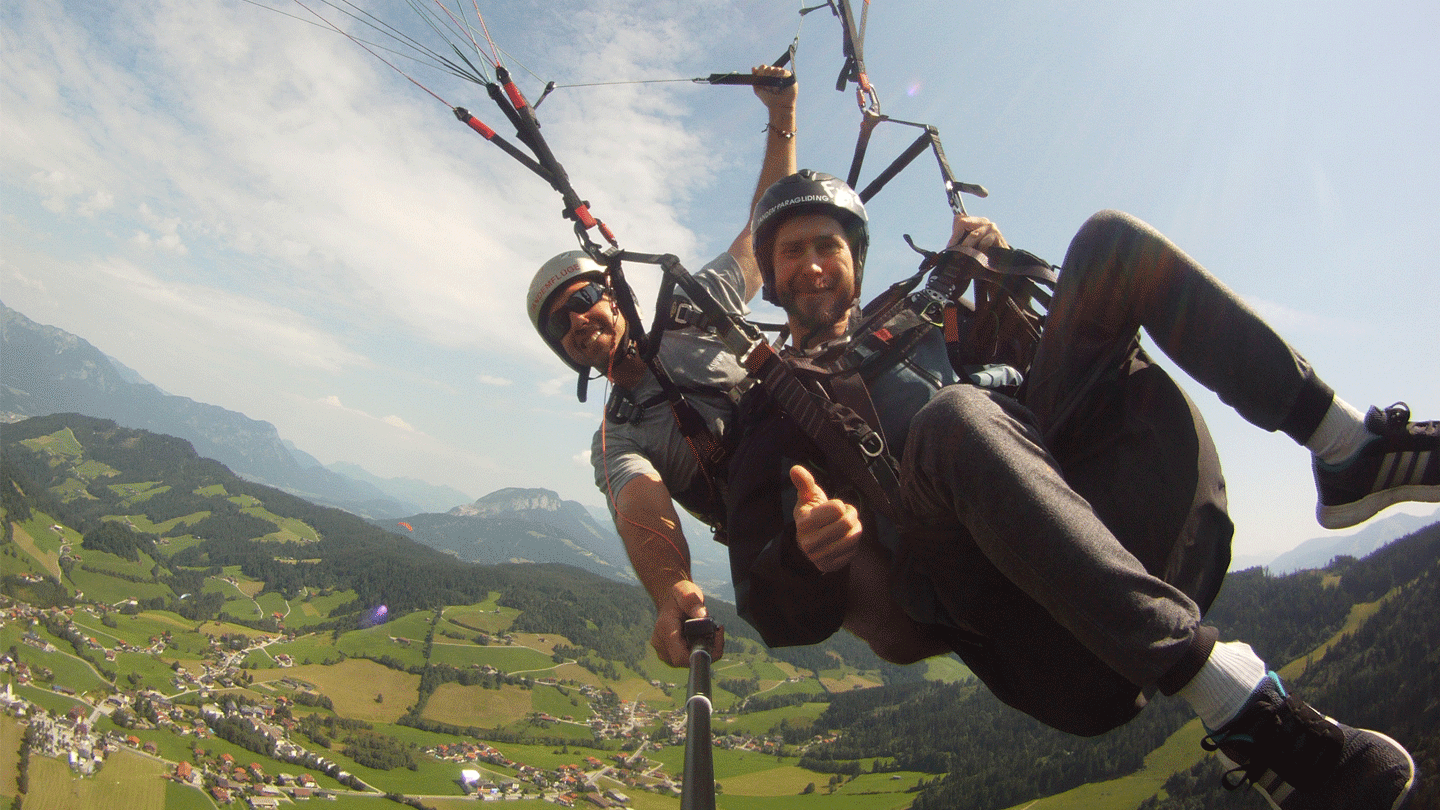 Two people paragliding over a mountain with short term memory loss.