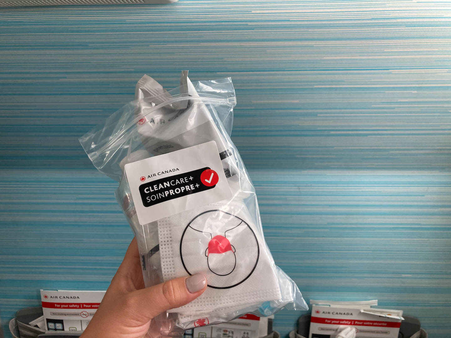 Person holding a bag of Air Canada masks.