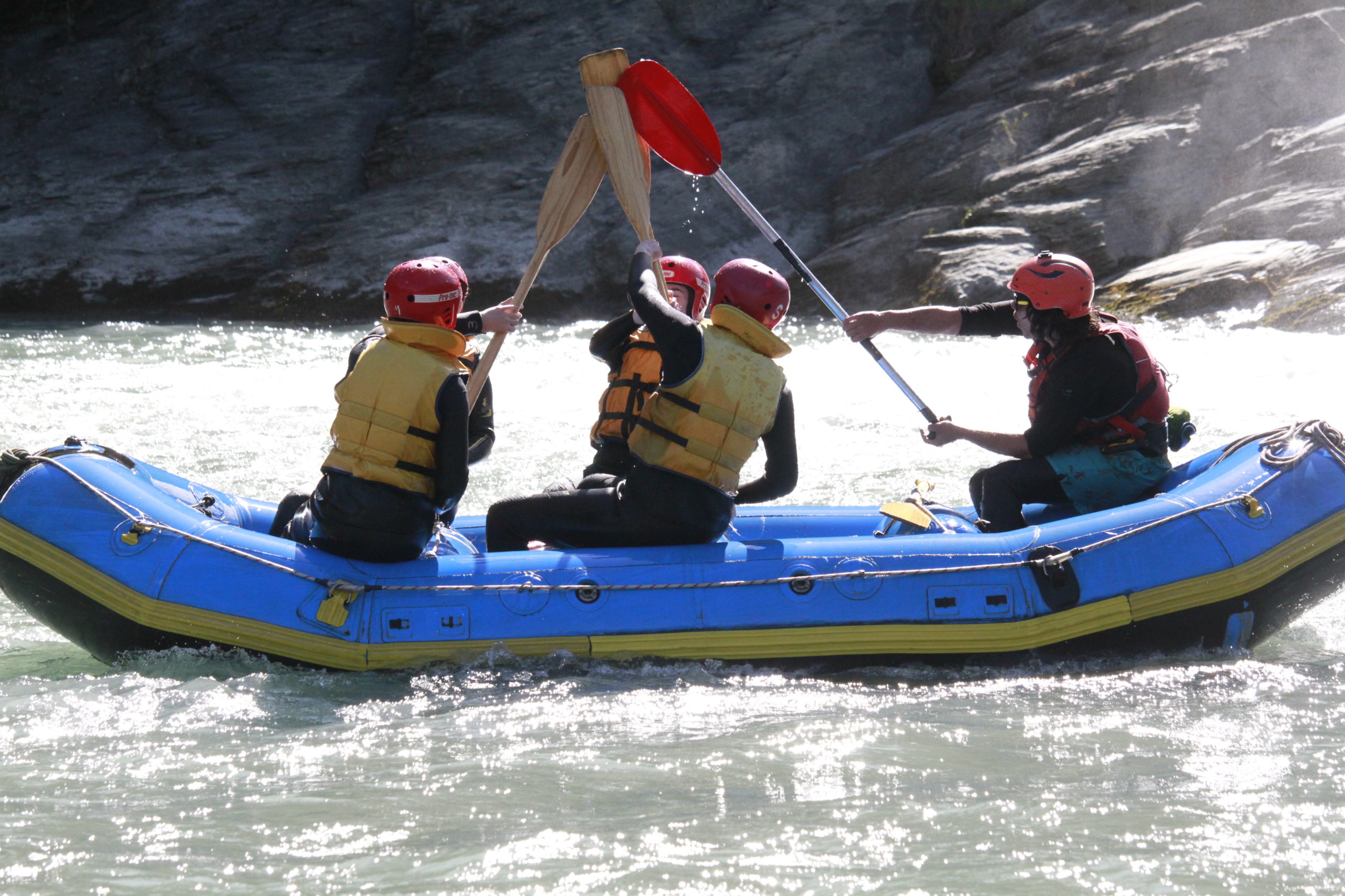 Four young friends white water rafting in Skippers Canyon, New Zealand.